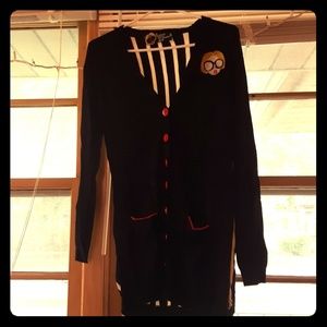 Black cardigan with red buttons.